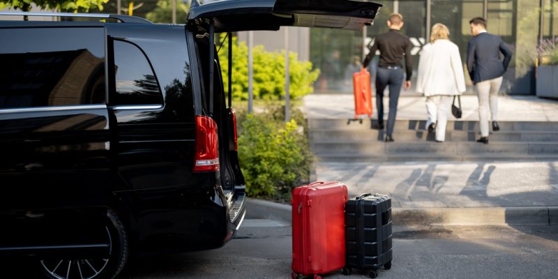 Driver helps a business couple carry their suitcases to the office or hotel